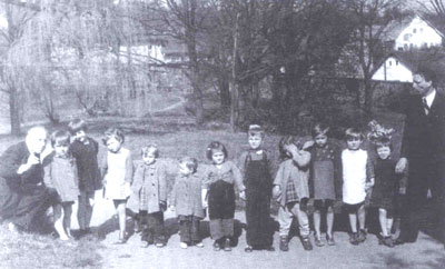  Kinder aus den Internierungslagern mit Premysl Pitter (links) und Zdenek Teichman im Garten des Schlosses Lojovice (1946)