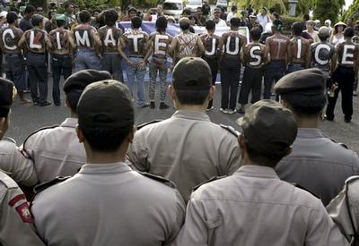 Activists paint their bodies for campaign against climate change during a demonstration as Indonesia