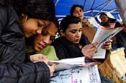 Mladí lidé studují materiály z informačního stánku k MDR na náměstí Míru (Foto: ČTK)